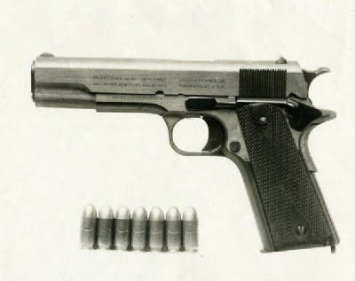 1911 pistol with 7 rounds of 45 ACP ammo next to it.